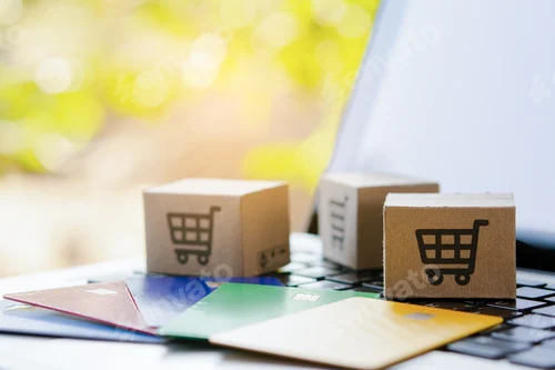 Preview: Shopping online. Credit card and cardboard box with a shopping cart logo on laptop keyboard.